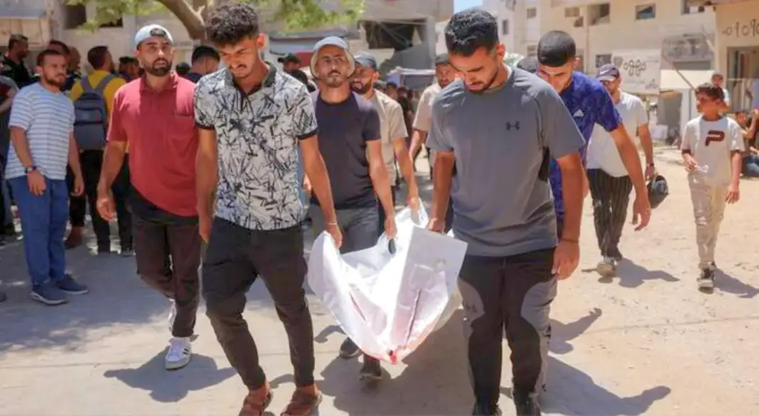 Men carry the body of one of several victims who were killed after a police station was was hit by Israeli bombardment in the Jabalia camp.